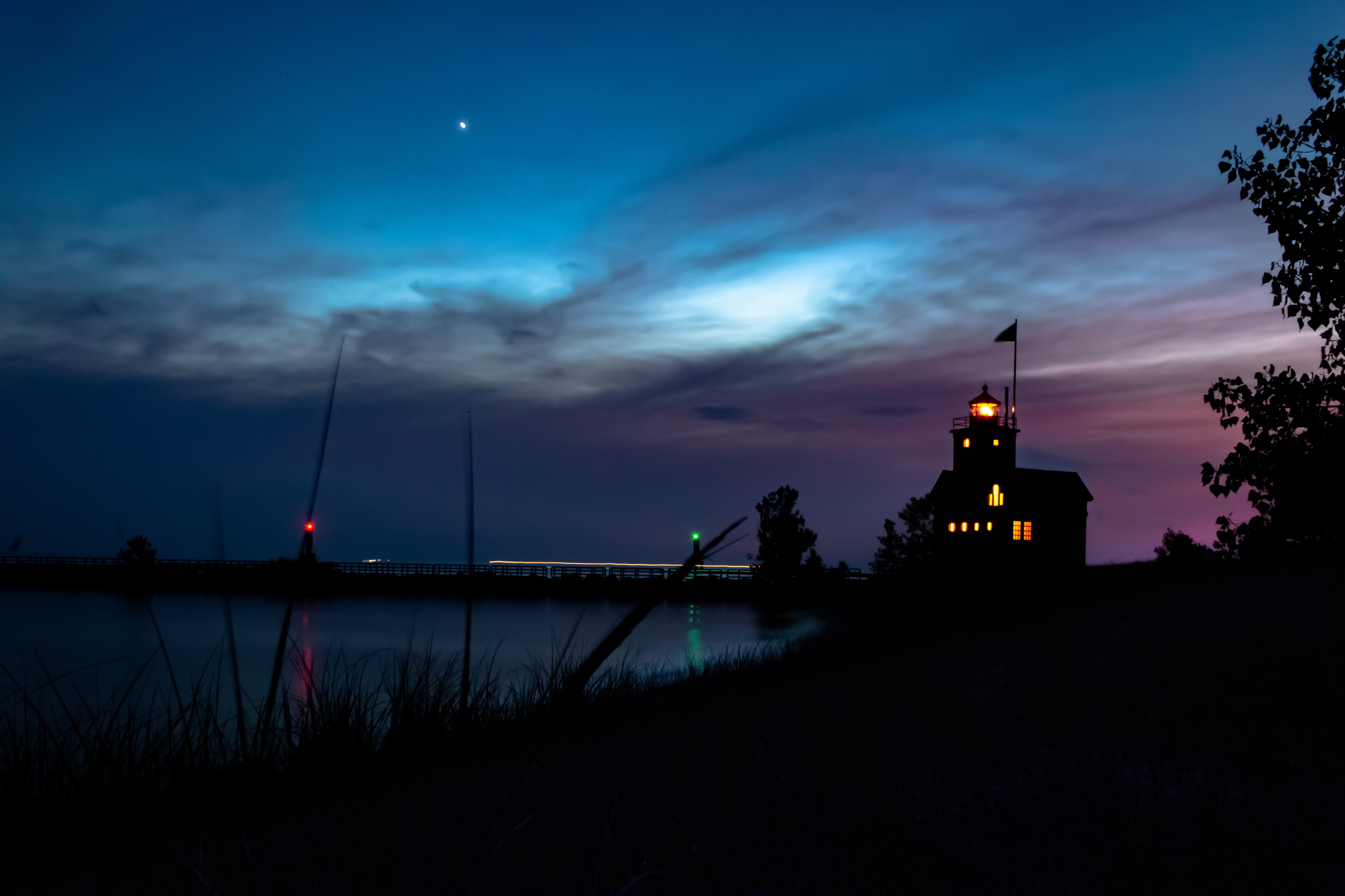 Silhouettes of grasses and Holland Harbor Lighthouse during sunset, Lake Macatawa